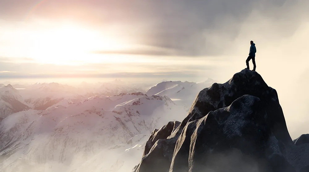Abenteuer und Erfolg: Ein Werbeagentur-Experte begrüßt den Sonnenaufgang vom Gipfel aus.